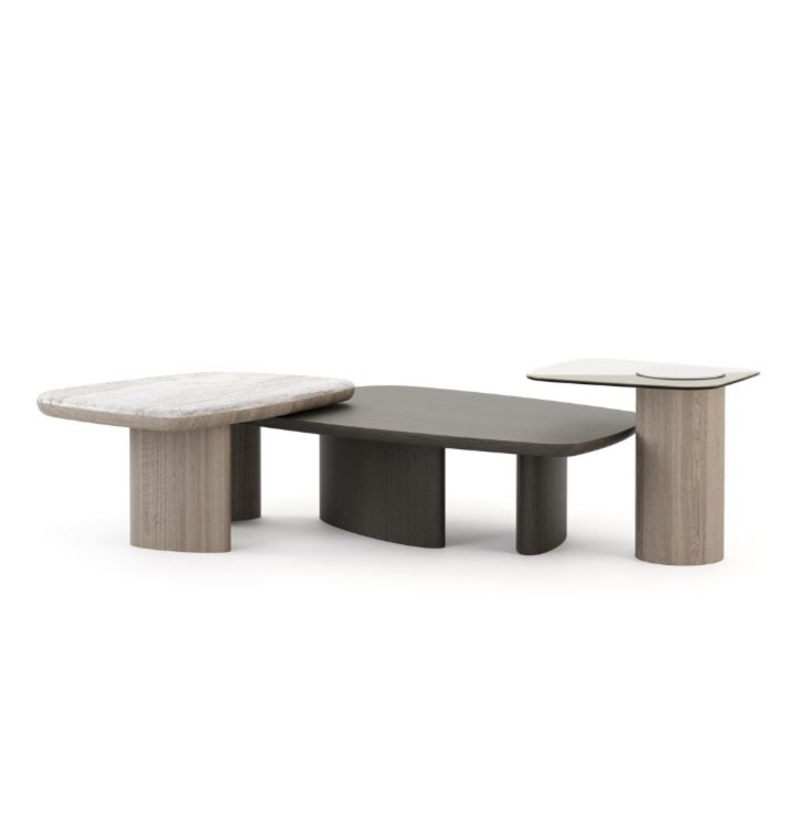 The Dolomites Coffee Table is shown as a three‑level composition of interconnected tables, each with a different surface: one in light wood, one in a dark matte finish, and one in a pale stone‑like material, supported by cylindrical wooden legs that emphasize its sculptural, layered design.
