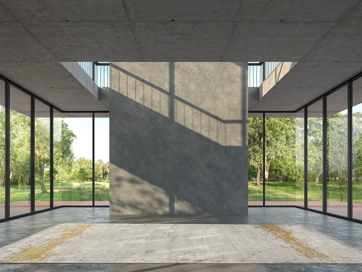 Foto of Abstract Rug in Gold & Sand colours placed in a room of concrete & glass windows through which you can see the green woods