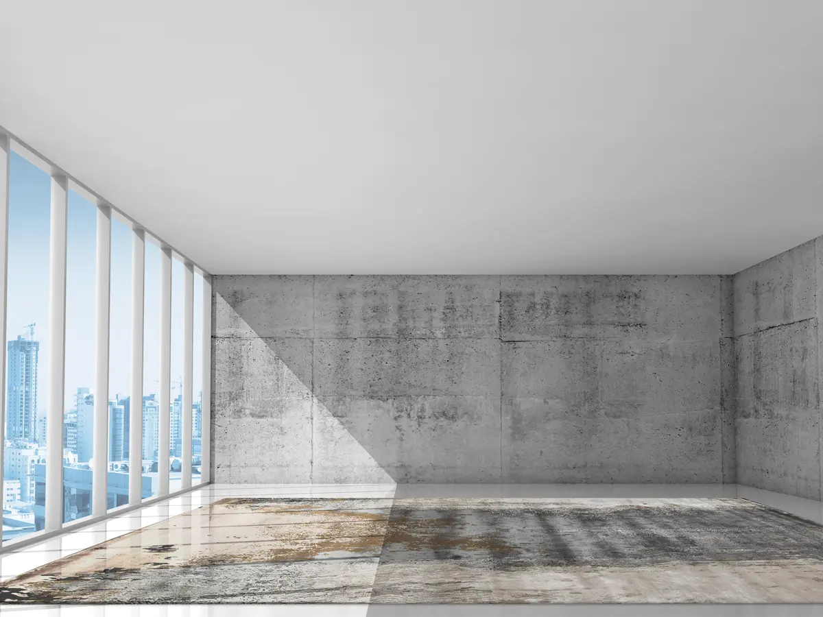 Foto of a building in a metropolitan city with concrete walls and a Rug with blue, brown and sand shades positioned in the middle covering the floor.