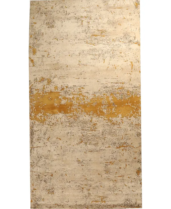 Foto di un tappeto dal disegno astratto nei toni oro e sabbia