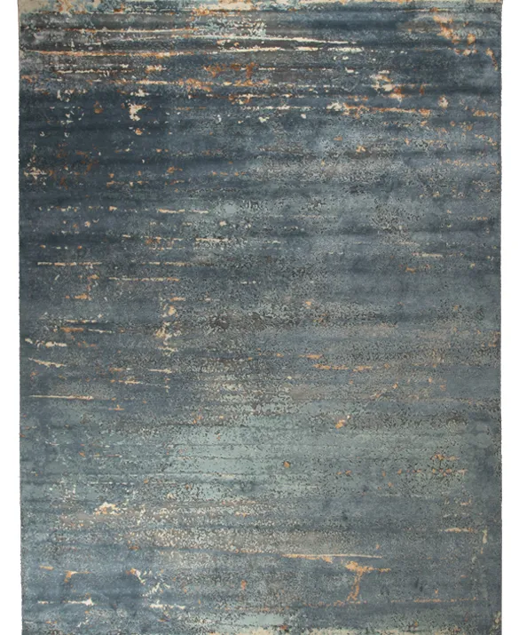 Foto di un tappeto dal disegno astratto nei toni del blu, grigio e sabbia
