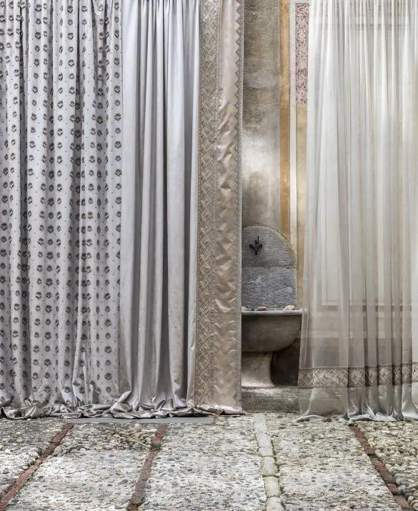 Una collezione di tende in cui rombi  in macramè si combinano  con lucenti e raffinate geometrie.