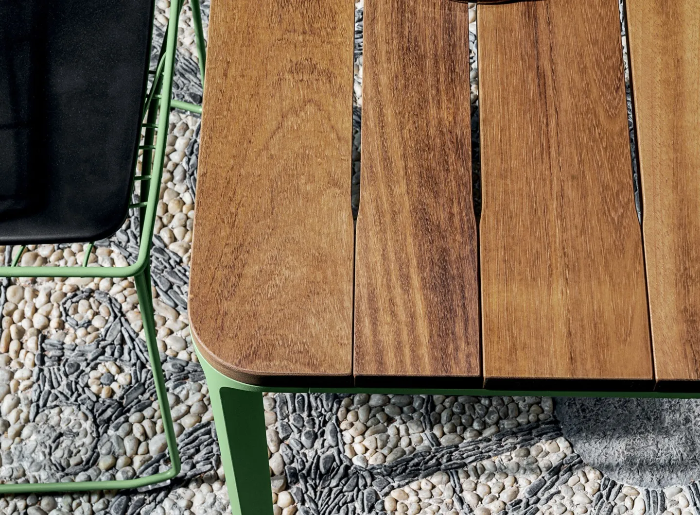 Slim outdoor dining table with iroko slats and Keyah chair in embossed green.
