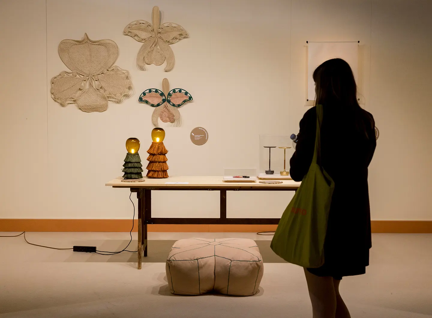 Girl observes a stand with wall decorations and handicrafts from Colombia