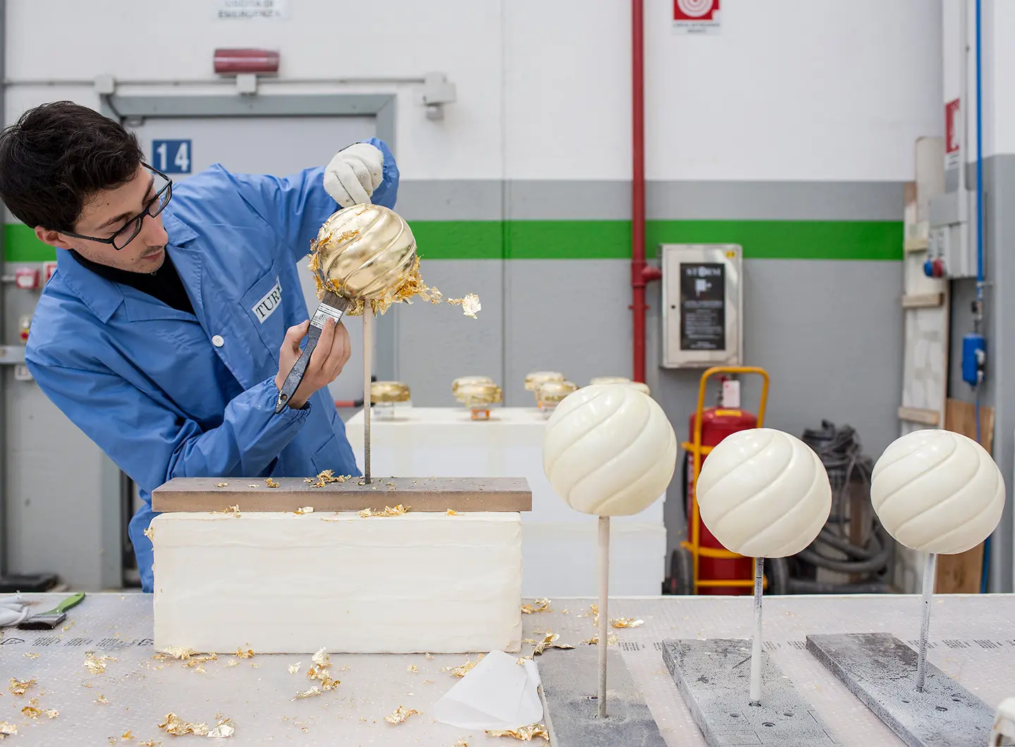 operaio che lavora ad un dettaglio con copertura di foglie d'oro, azienda Turri