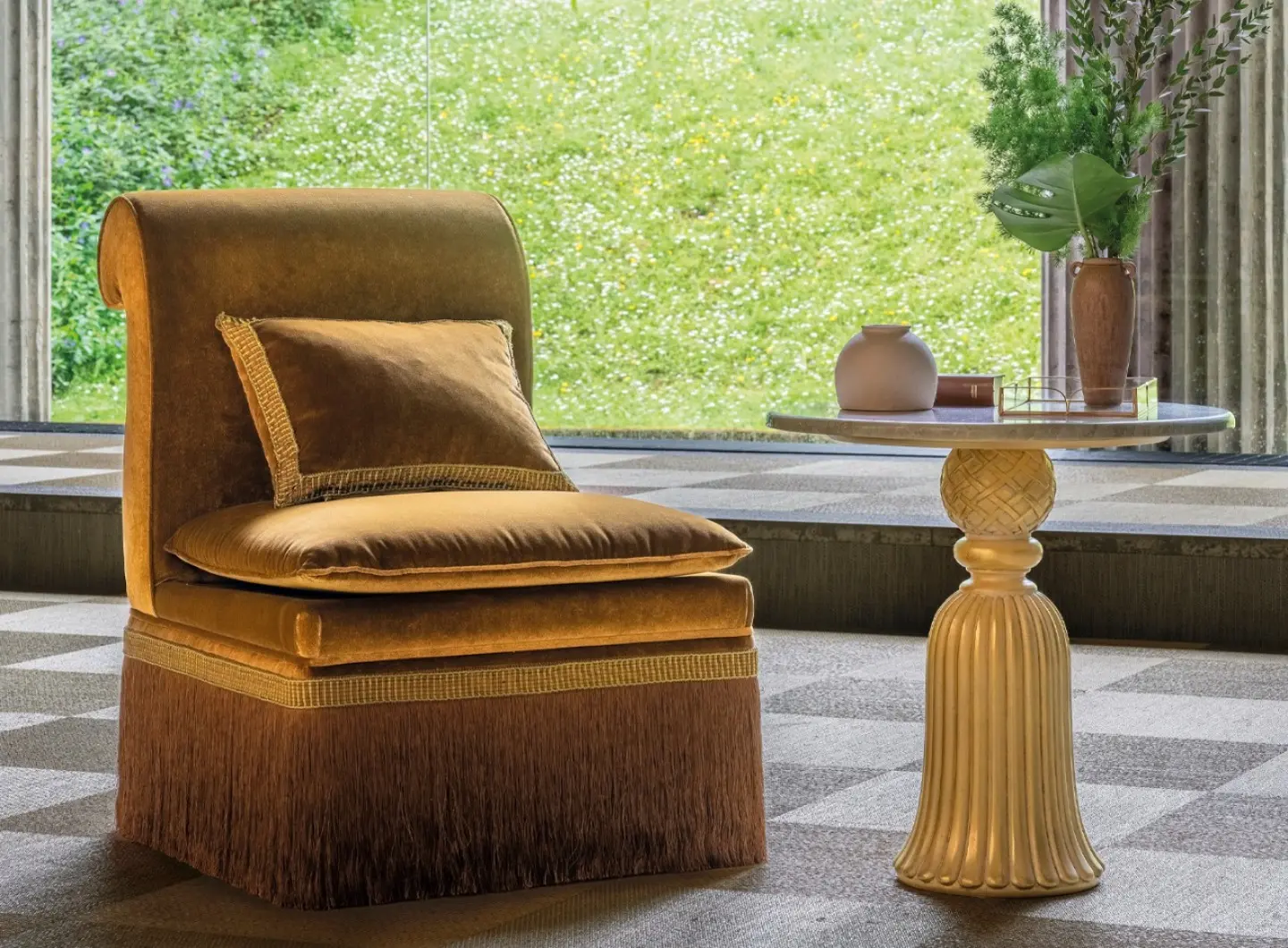 Poltroncina in velluto con cuscino e frangia decorativa.