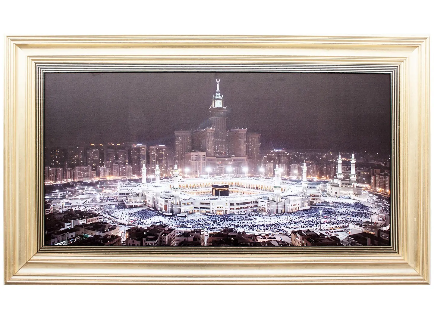 Veduta notturna della Mecca: minareti illuminati e atmosfera sacra. Cornice in legno massello dorato a foglie con bordo interno nero e oro, che trasmette solidità, luce e maestosità.
