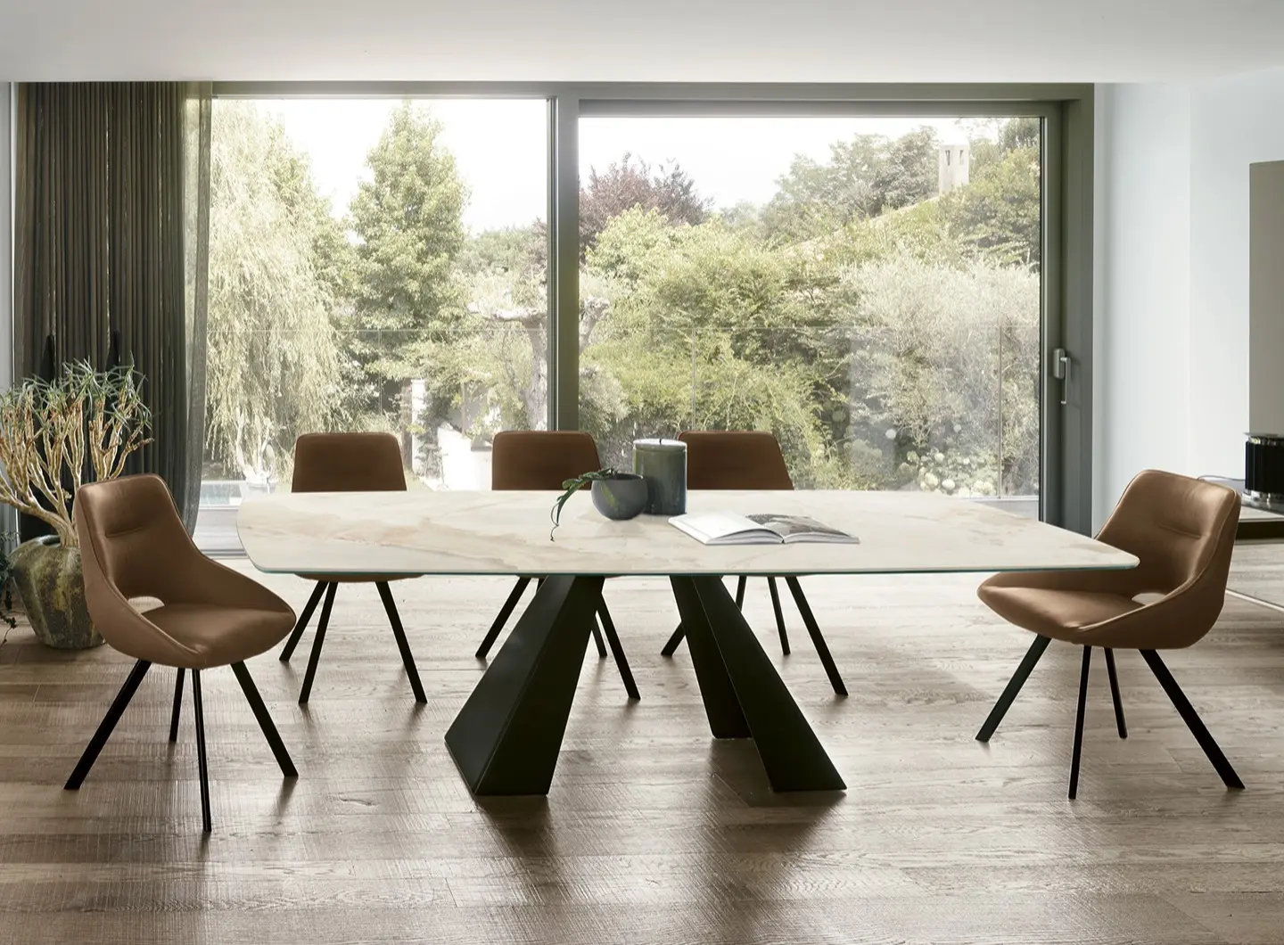 Tavolo TAURUS fisso con basamento in metallo verniciato Nero 0110. Piano a botticella in gres porcellanato effetto marmo Royal Ivory 3638. Sedie: Kudo SE1C4 Madia: Demetra MA123