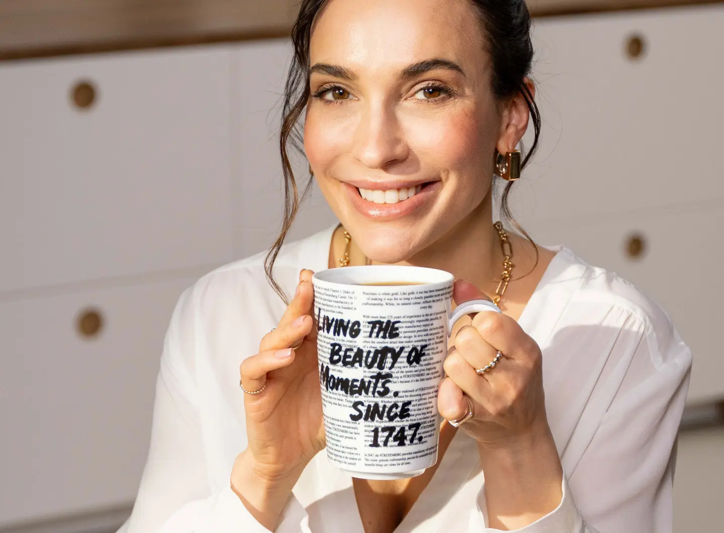 Woman holding a porcelain mug in her hands