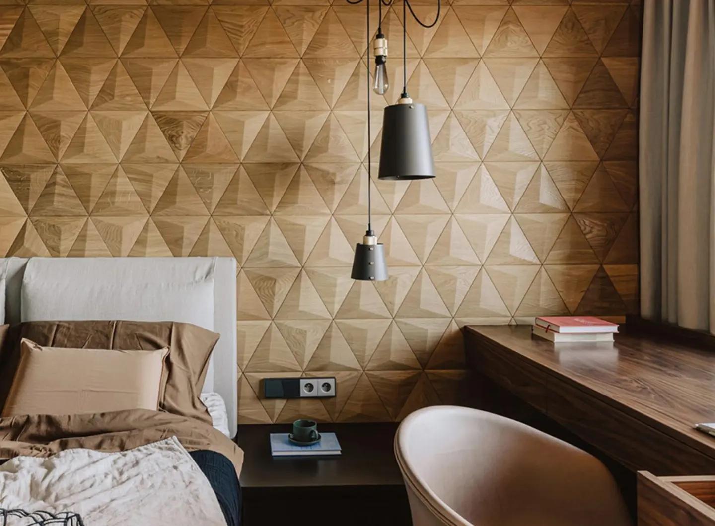 Cozy bedroom and home office featuring a 3D oak wood accent wall in a triangle pattern, black pendant lights, and a wooden desk.