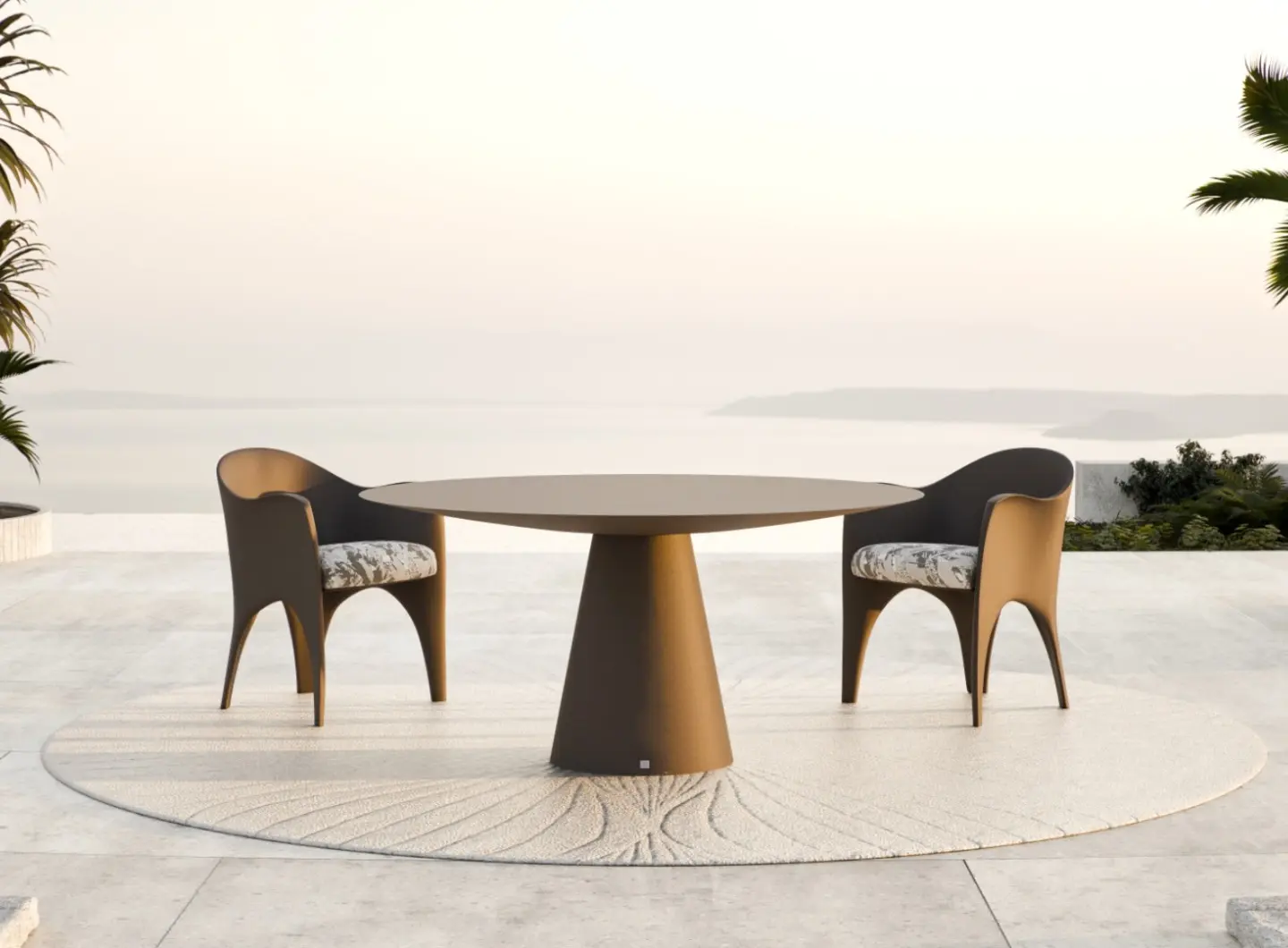 OCEANO Dining Table with two sculptural outdoor armchairs on a terrace overlooking the sea.