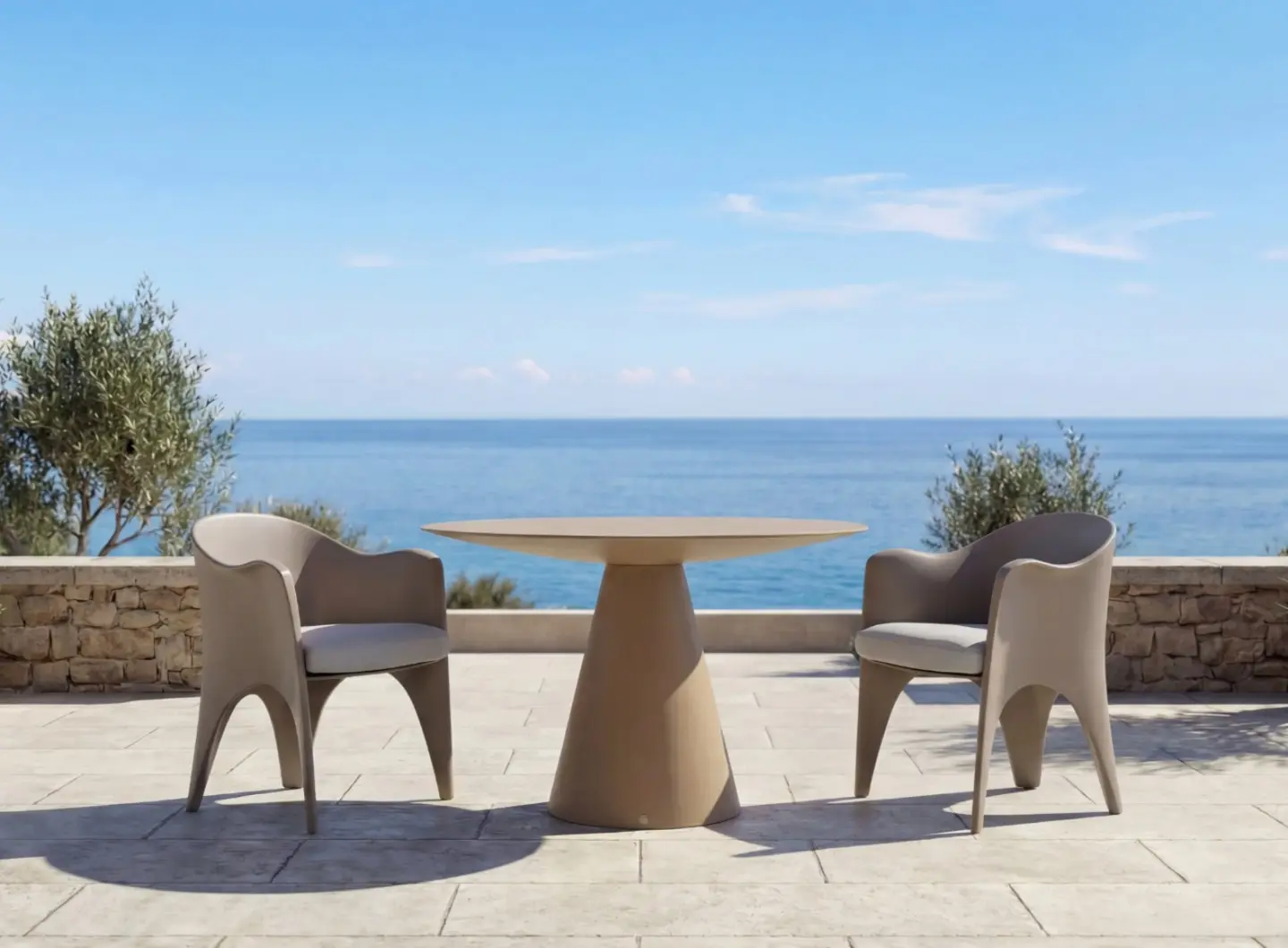 OCEANO Dining Table on a sea-view terrace, paired with two sculptural outdoor armchairs.