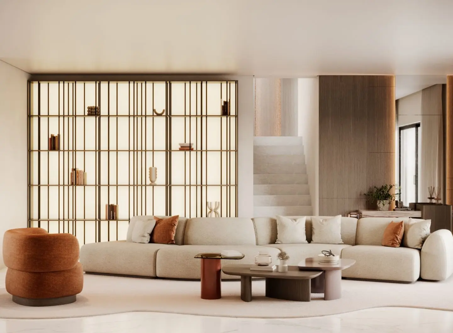 A warm modern living room featuring the Stone Sofa in soft neutral tones paired with sculptural Dolomites Coffee Tables, complemented by a rust Dolomites armchair and a backlit shelving feature to create an inviting composition that highlights luxury living room furniture.
