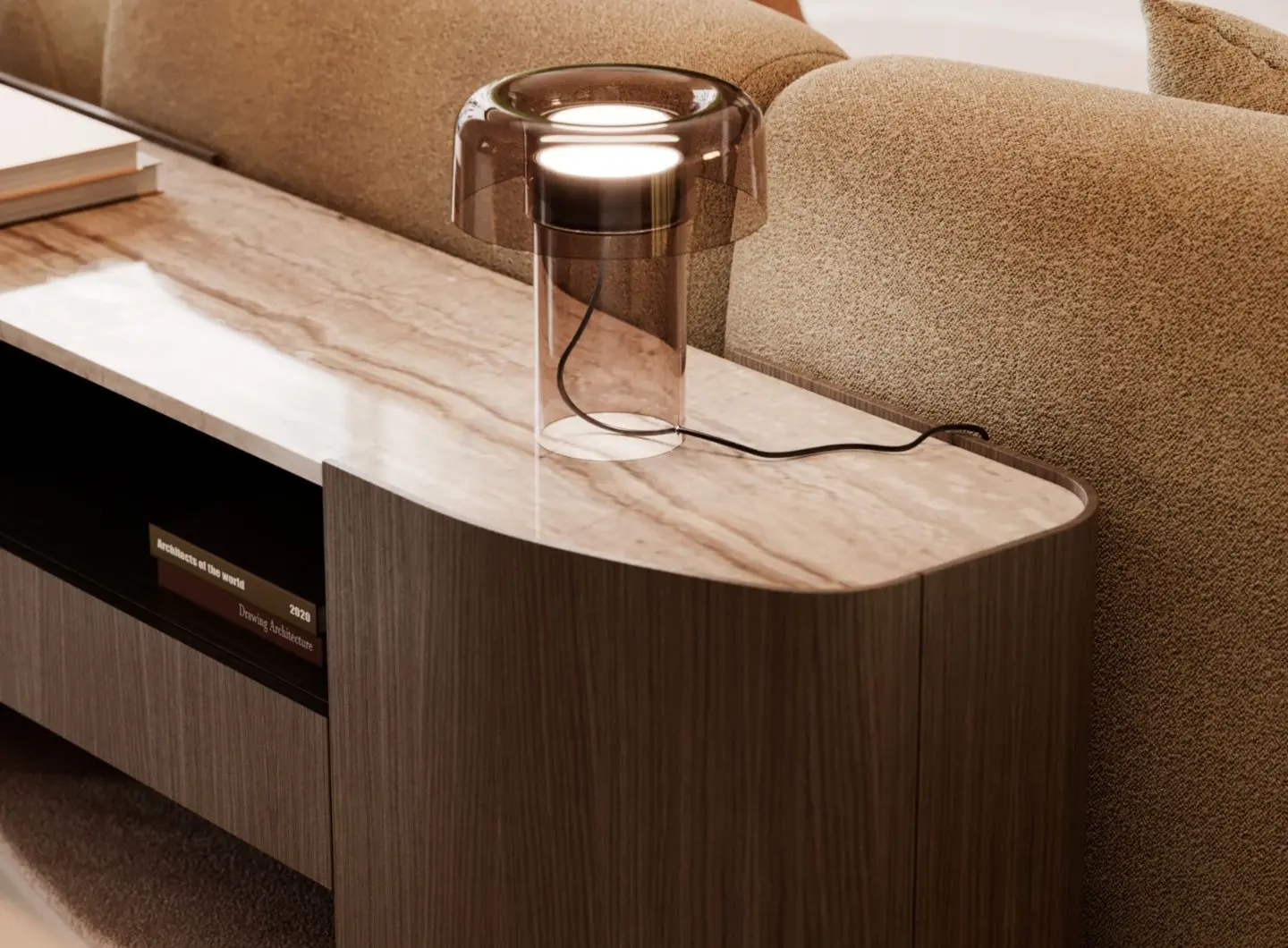 The low Stone console table, with a marble top and wooden base, is paired with a modern table lamp with a glass base and placed behind a beige sofa with a textured finish, with a few books displayed on the lower shelf.