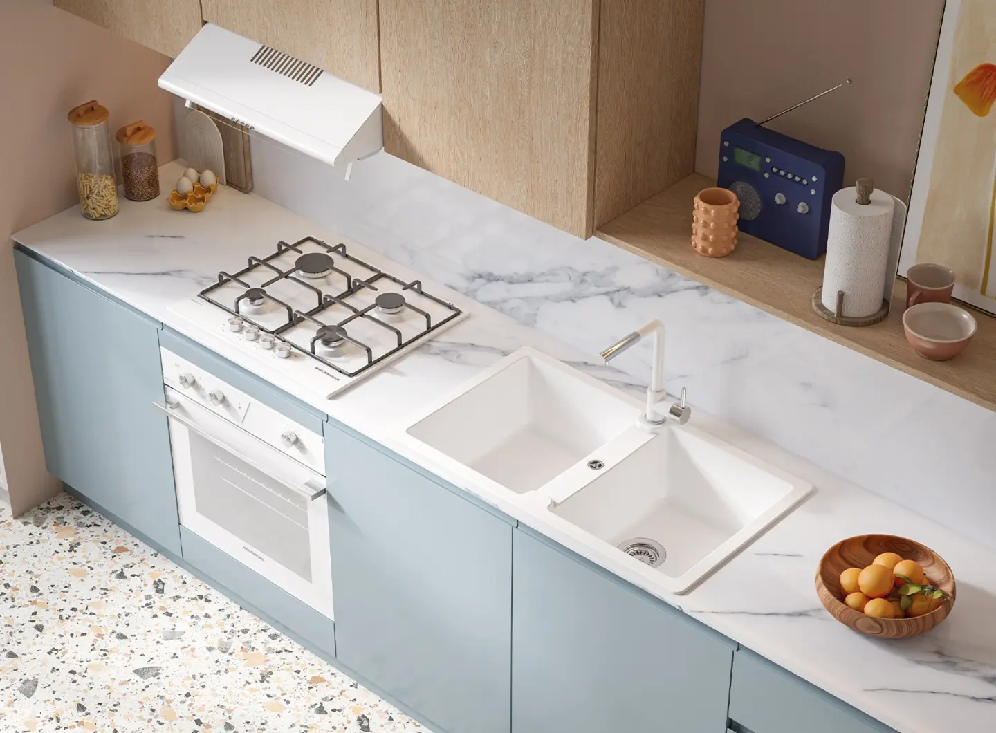 A bright kitchen with a young and fresh style, characterized by sugar-blue lower cabinets and light wood wall units. The white marble countertop with gray veining hosts a white double-bowl sink with a matching matte white mixer tap and a white gas hob. A white built-in oven is seamlessly integrated beneath the burners, maintaining a clean and essential color continuity.