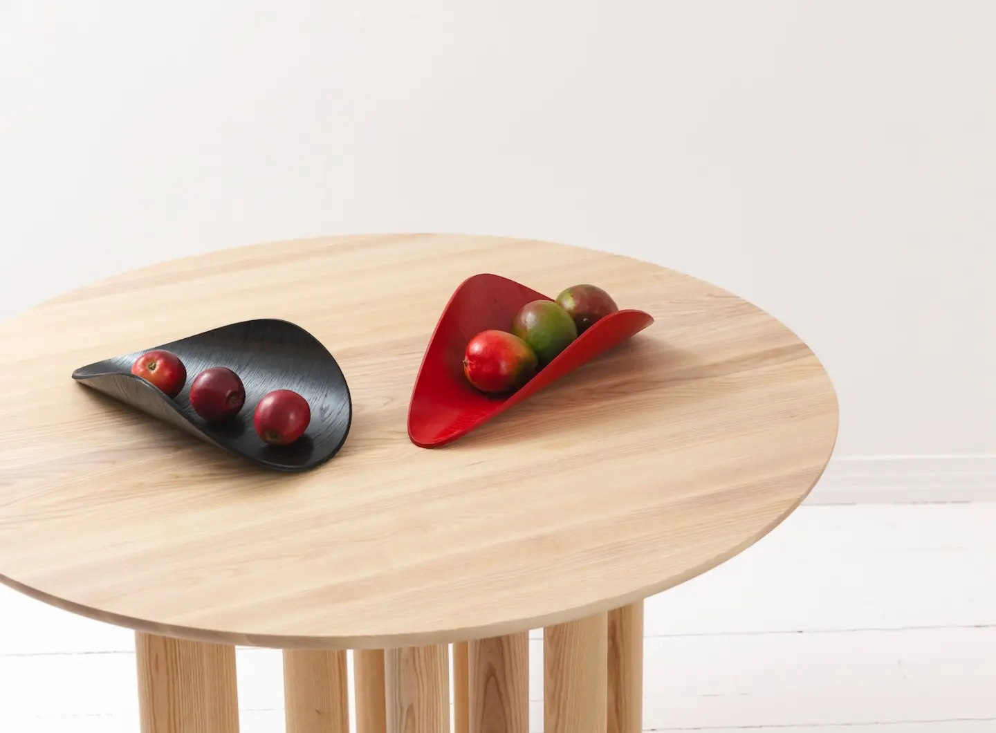 Round table in ash with multiple legs & red and black Snail dishes