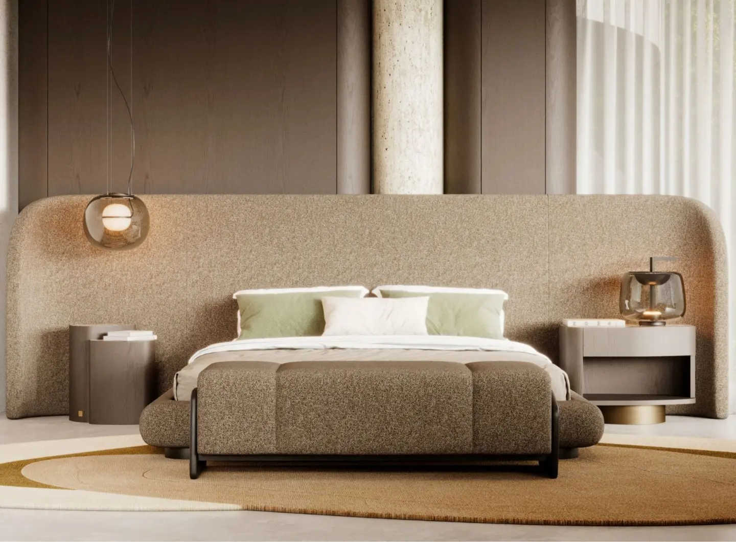 The Dolomites Side Table is shown in a bedroom with a large upholstered headboard, appearing as a muted brown nightstand with a simple, organic form placed beside the bed, styled with books and illuminated by a spherical pendant light.