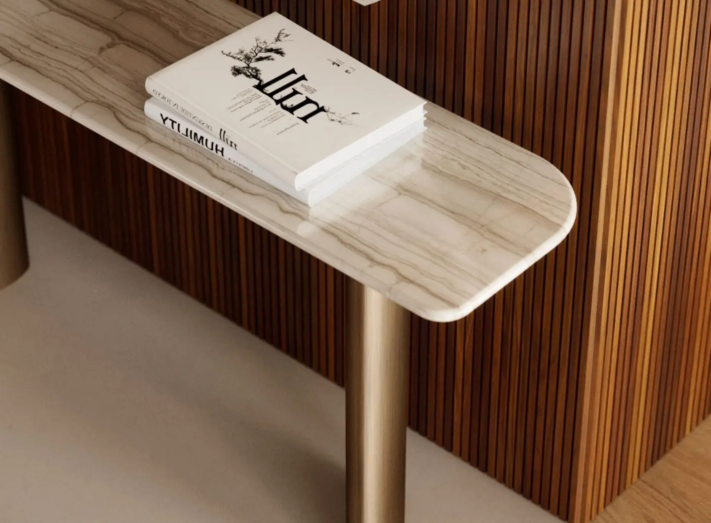 The Dolomites Console is shown in close view with a rounded marble top and cylindrical metallic legs, placed against a wall with vertical wooden slats and styled with two stacked books on its surface.