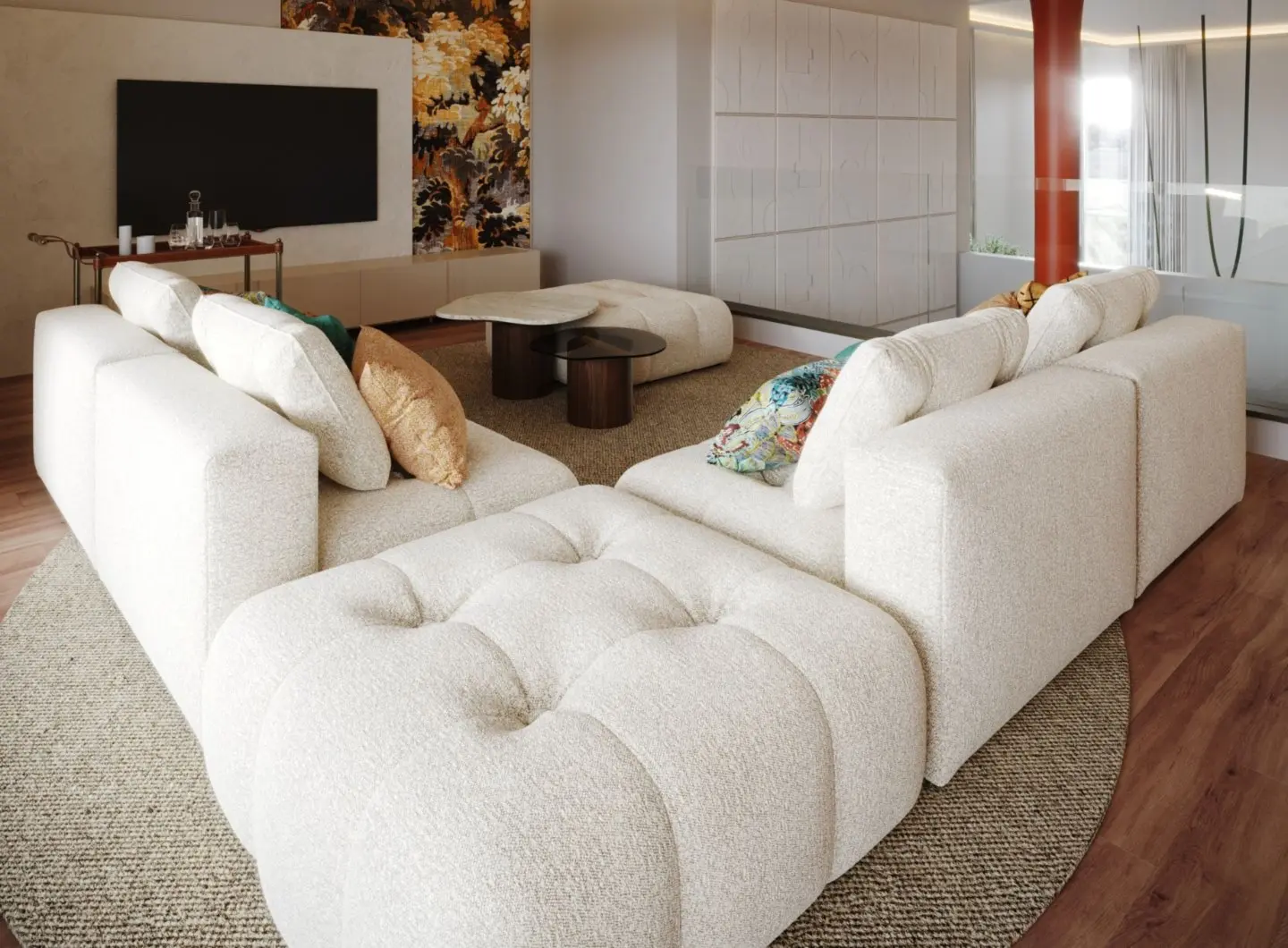 The Antónia Sofa is displayed as a large U‑shaped modular sectional in textured cream fabric with tufted seating and colorful patterned pillows, centered around two contrasting coffee tables on a woven beige rug, set within a bright living room featuring a decorative wall panel, a console with glassware, white geometric wall panels, and tall plants near a glass partition.
