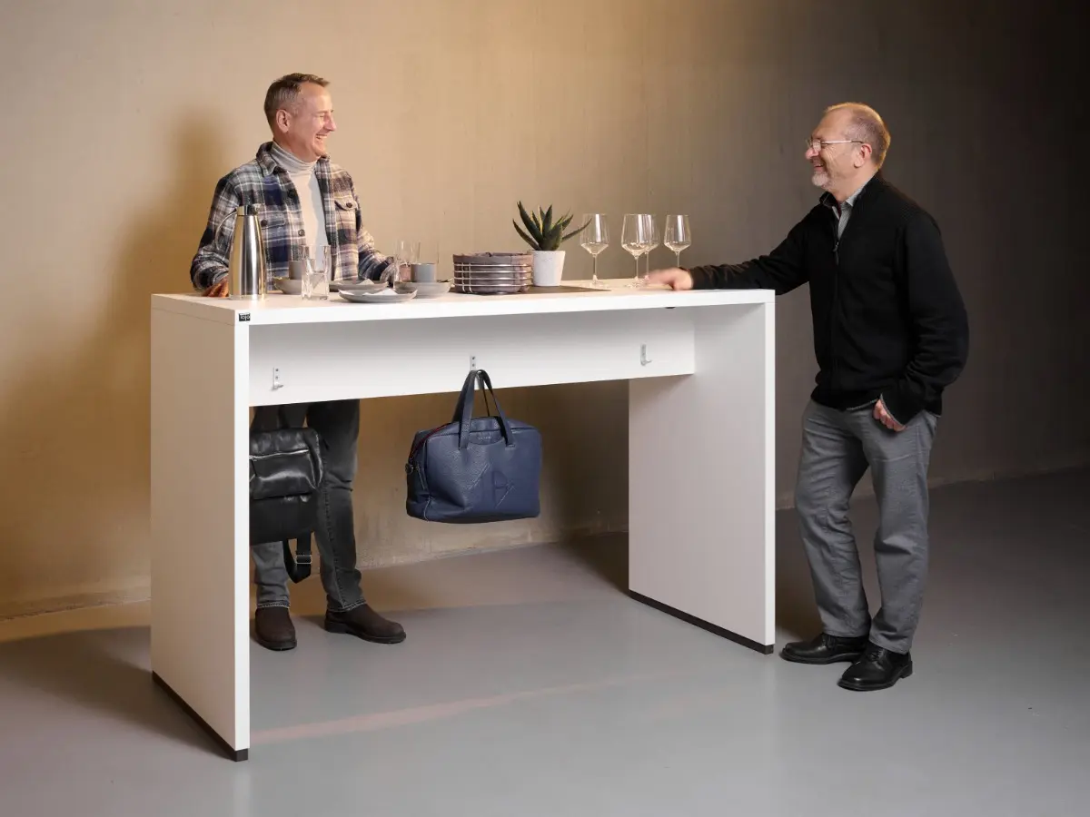 Due persone sono in piedi a un tavolo da ponte bianco.