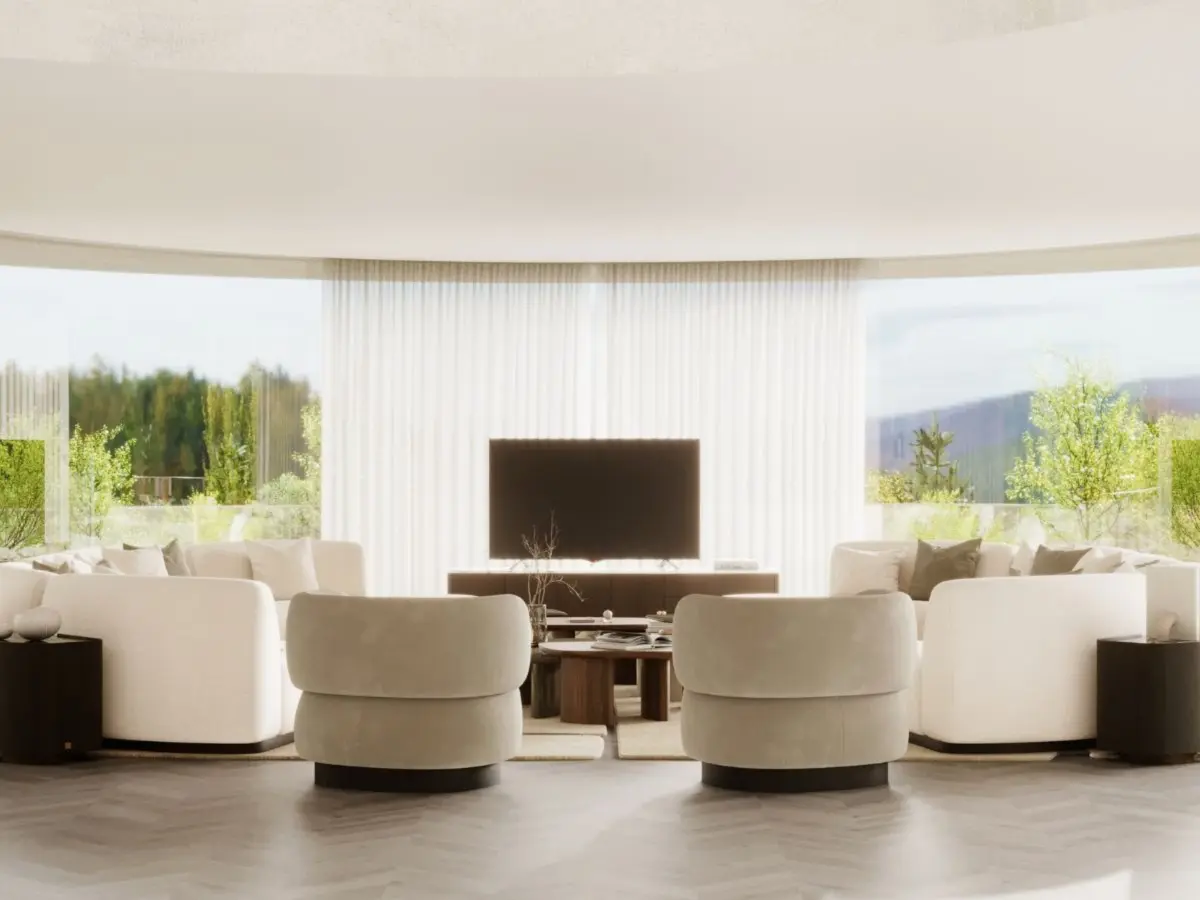 The Dolomites Armchair appears as a pair of plush, rounded chairs in a light neutral tone, placed in a bright living room with floor‑to‑ceiling windows, arranged alongside curved sofas and a central coffee table in a serene, open space.
