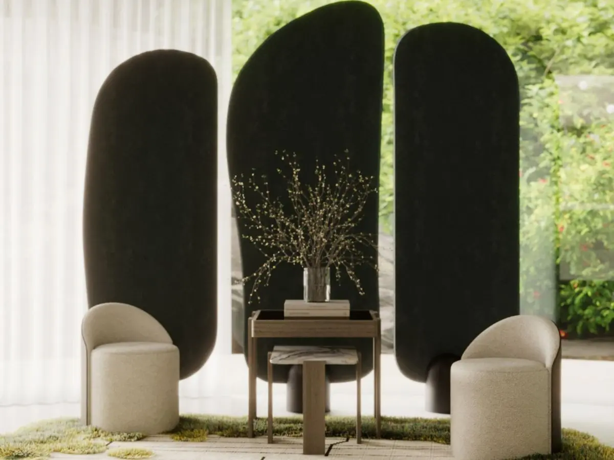 The Elis Stool appears as a pair of rounded beige upholstered chairs placed on either side of a small wooden table, each with a cylindrical base and a curved backrest, set in a nature‑inspired interior with sculptural dark panels and a textured green‑and‑beige rug.