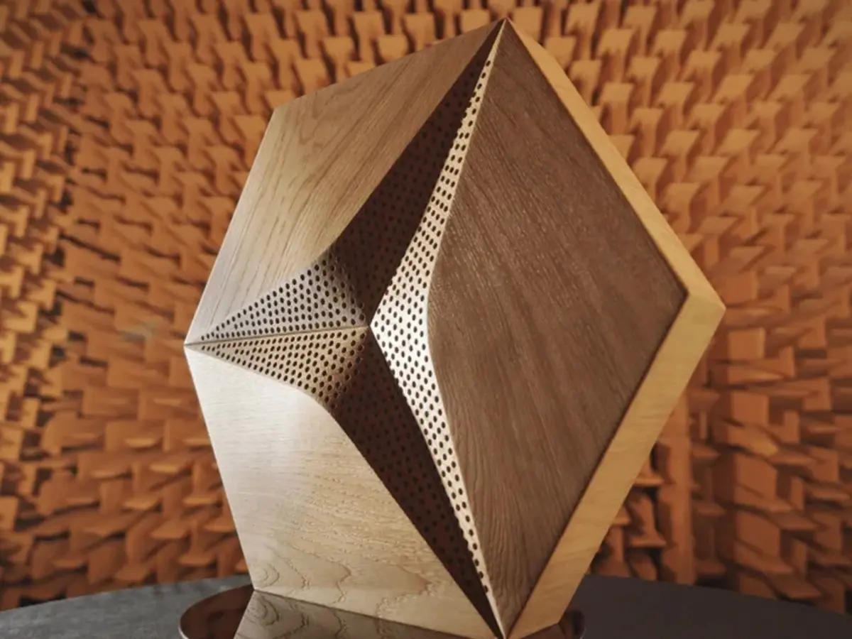 Modern luxury living room featuring a dark grey wall with an installation of acoustic hexagonal oak wood panels, large sofa and TV.