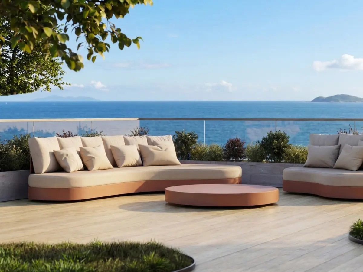 HARMONY Sofa by GANSK on a sea-view terrace, a low modular outdoor sofa with plush cushions and a round coffee table.