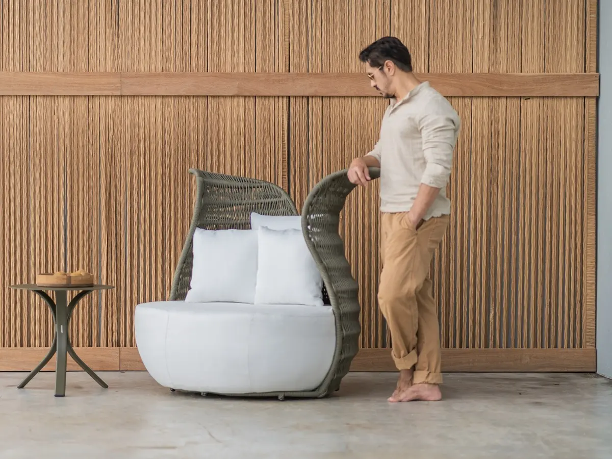 An armchair reminiscent of a flower. Made of green nautical rope and upholstered in white on the seat.