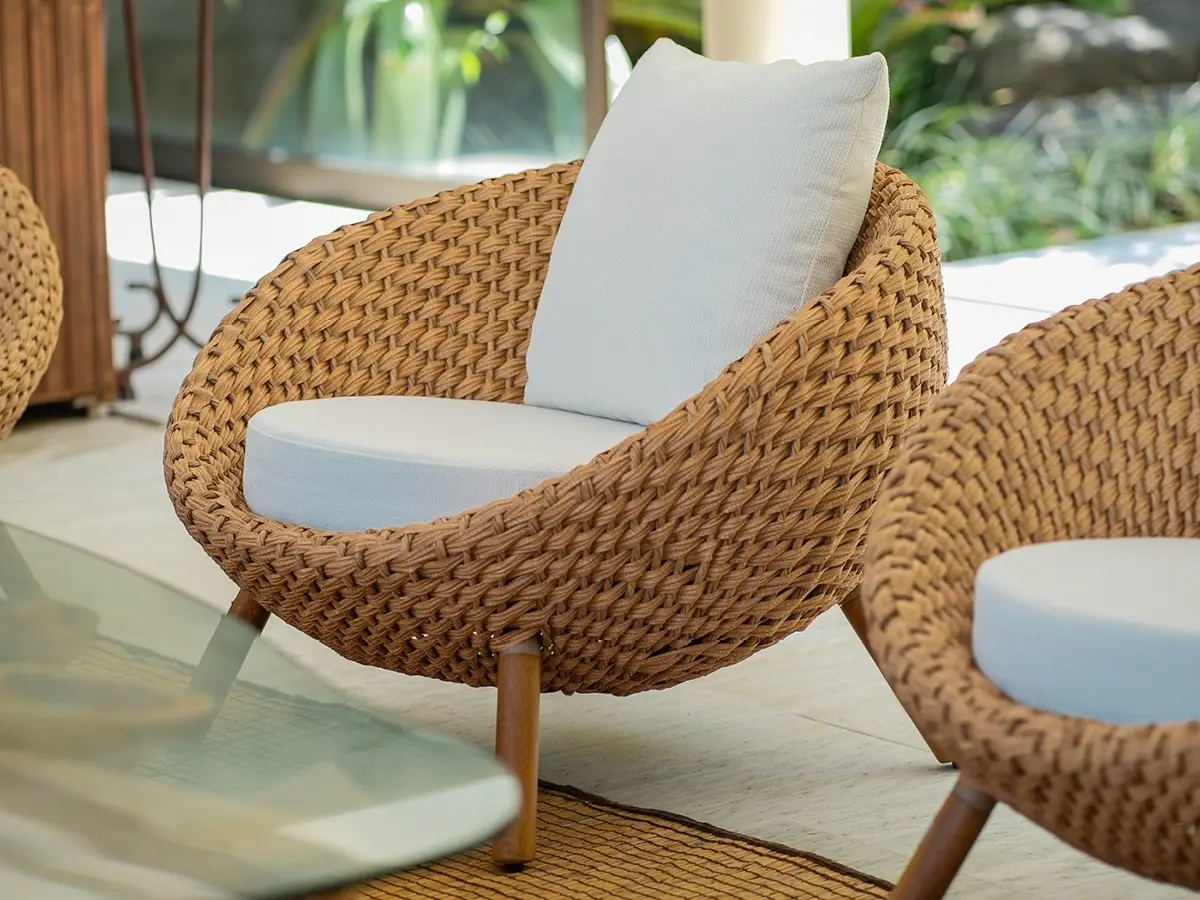 Woven banana fiber armchair. The armchair has a spherical shape and a white fabric seat.