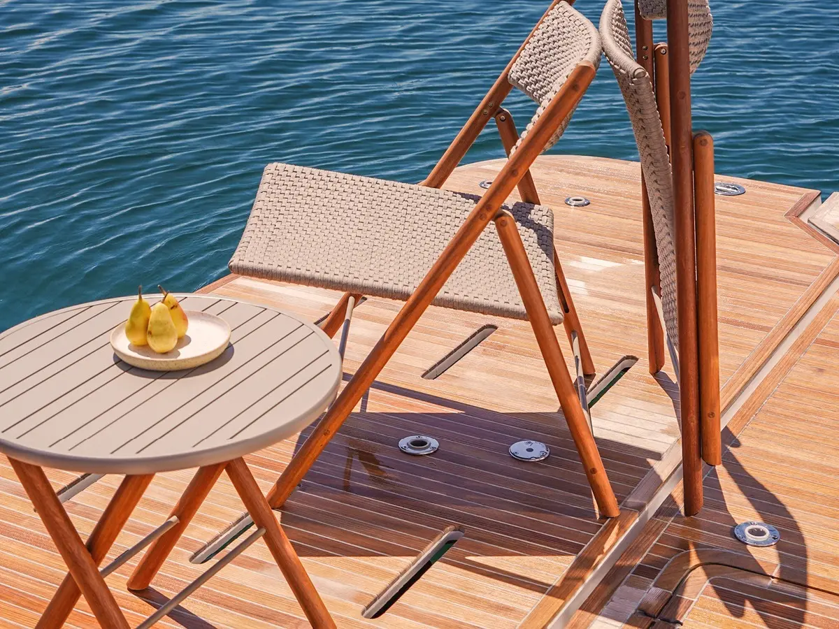 Two folding armchairs leaning against each other. The seat and backrest are woven with gray rope and the frame is made of wood.