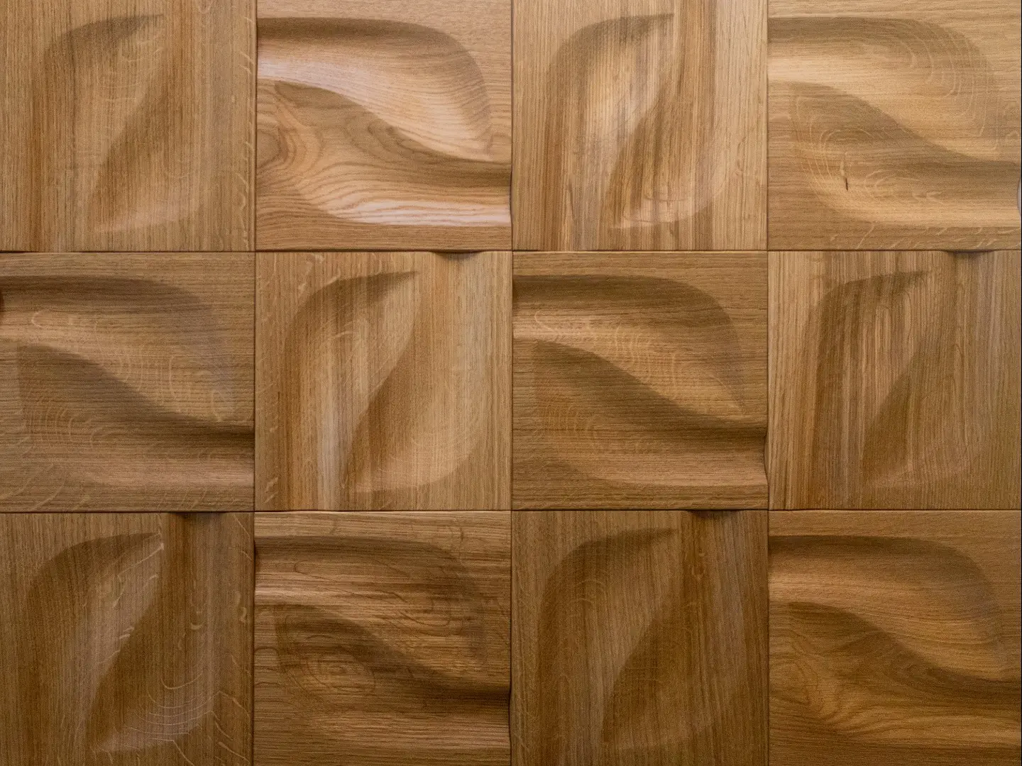 Close-up of 3D oak wood wall panels in a natural finish, featuring a Leaf or wave pattern, and showcasing the natural oak grain and sculptural depth.