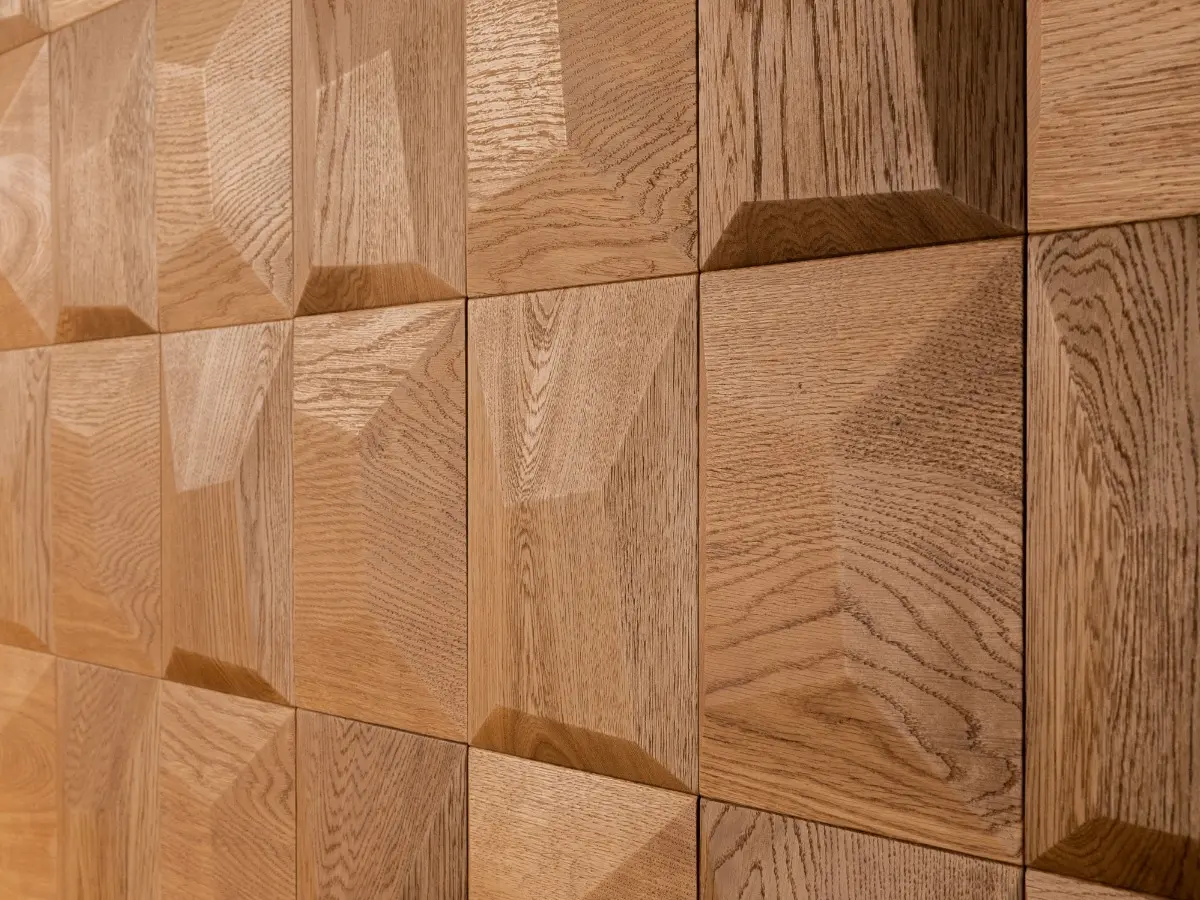 Perspective close-up of 3D oak wood wall panels in a square pillow pattern, showcasing natural grain and texture.