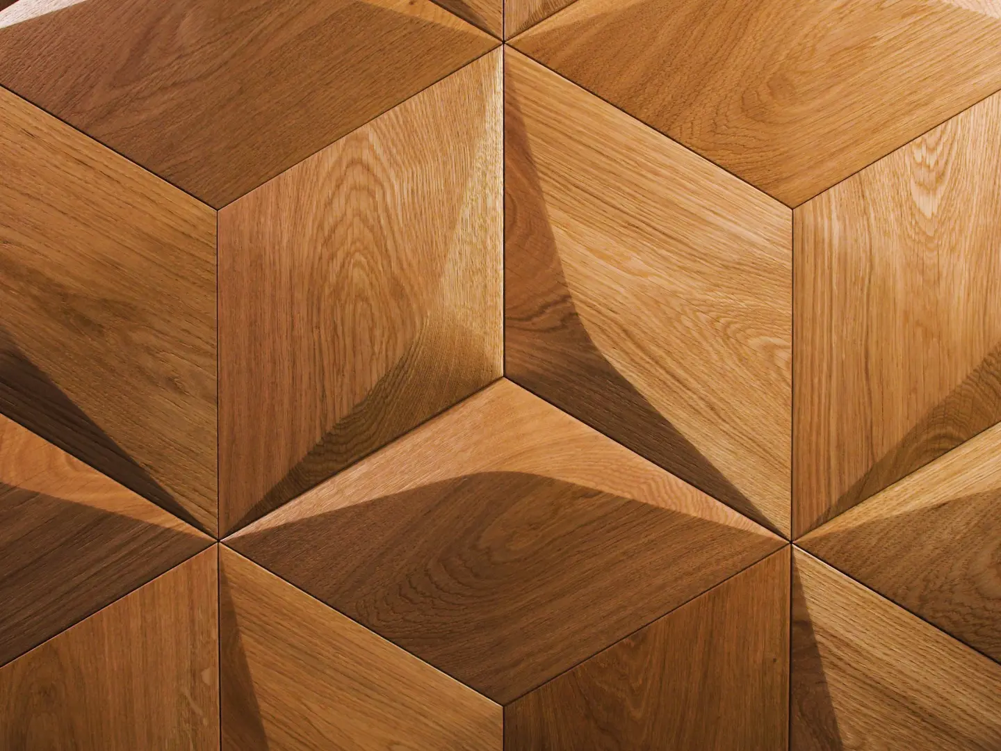 Close-up of 3D oak wood wall panels in a diamond pattern, showcasing natural wood grain and precise geometric edges.
