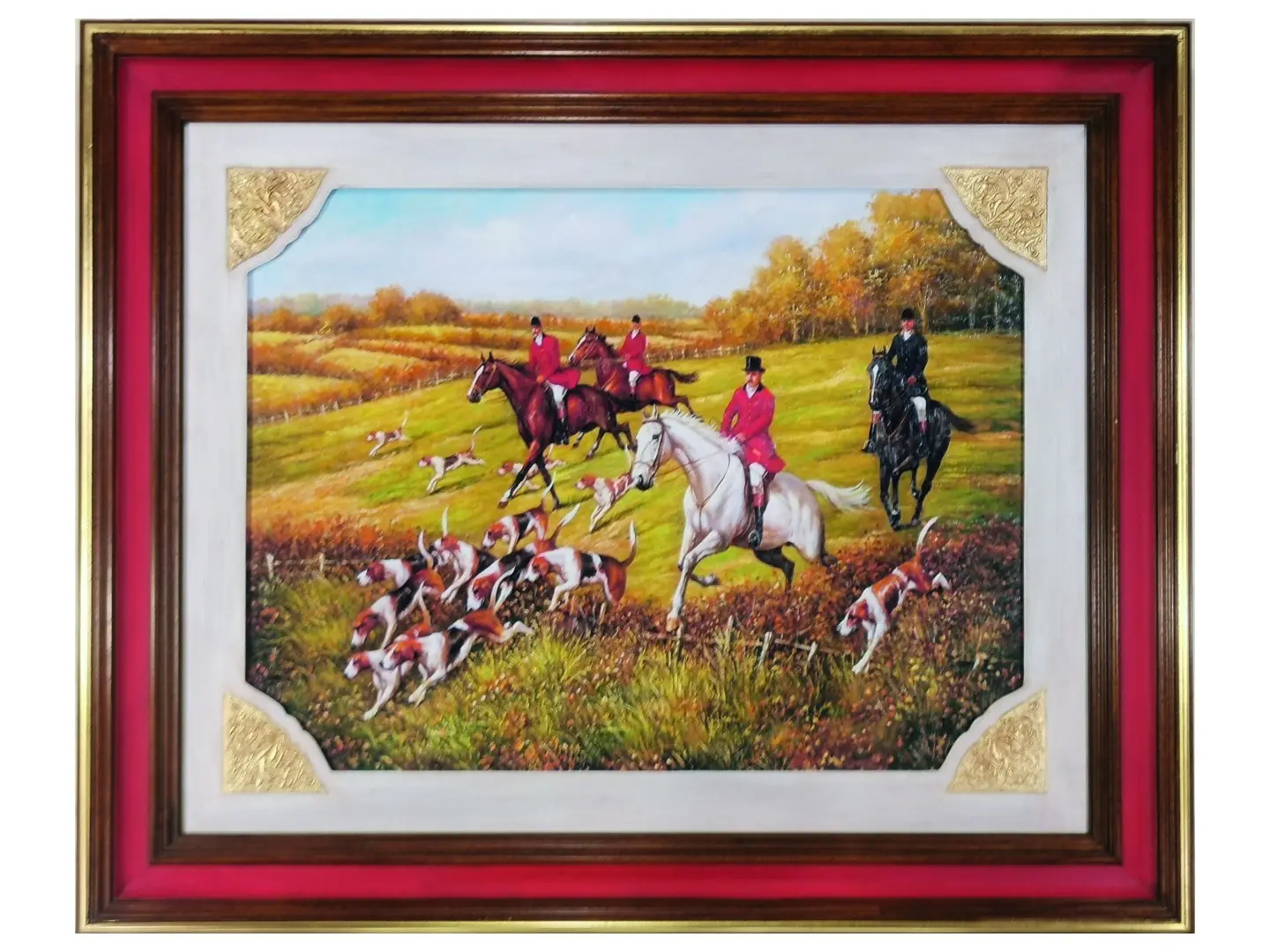 Quadro con scena tradizionale di caccia alla volpe inglese. Si vedono cavalieri a cavallo che corrono nella campagna, indossando le tipiche giacche rosse della tradizione equestre. I cavalli sono in movimento e la scene trasmette energia e dinamismo. L'immagine è racchiusa in una cornice in legno massello con tonalità noce e rosso, che richiama il colore delle giacche dei cavalieri. Agli angoli sono presenti decorazioni dorate a foglia, che aggiungono un tocco elegante e raffinato all'insieme.