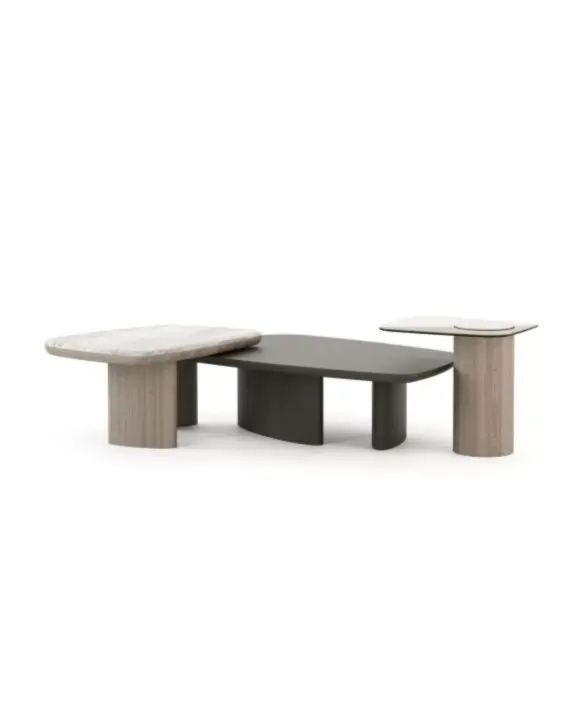 The Dolomites Coffee Table is shown as a three‑level composition of interconnected tables, each with a different surface: one in light wood, one in a dark matte finish, and one in a pale stone‑like material, supported by cylindrical wooden legs that emphasize its sculptural, layered design.