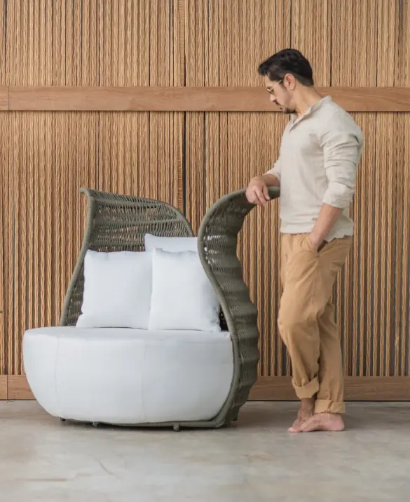 An armchair reminiscent of a flower. Made of green nautical rope and upholstered in white on the seat.