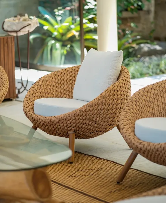 Woven banana fiber armchair. The armchair has a spherical shape and a white fabric seat.