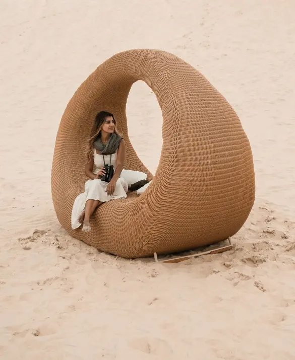 Chaise longue made of synthetic wicker with a shape similar to that of a handbag.