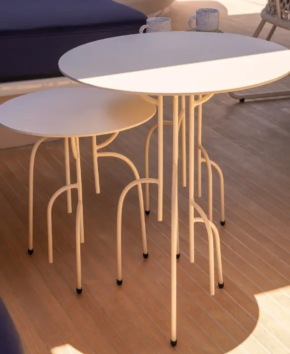 White coffee tables at two different heights. The legs are slender and branch out like roots.