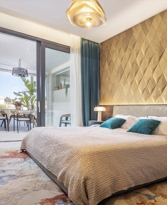 Modern bright bedroom featuring a 3D oak wood diamond-shaped accent wall, teal cushions, and a terrace view.