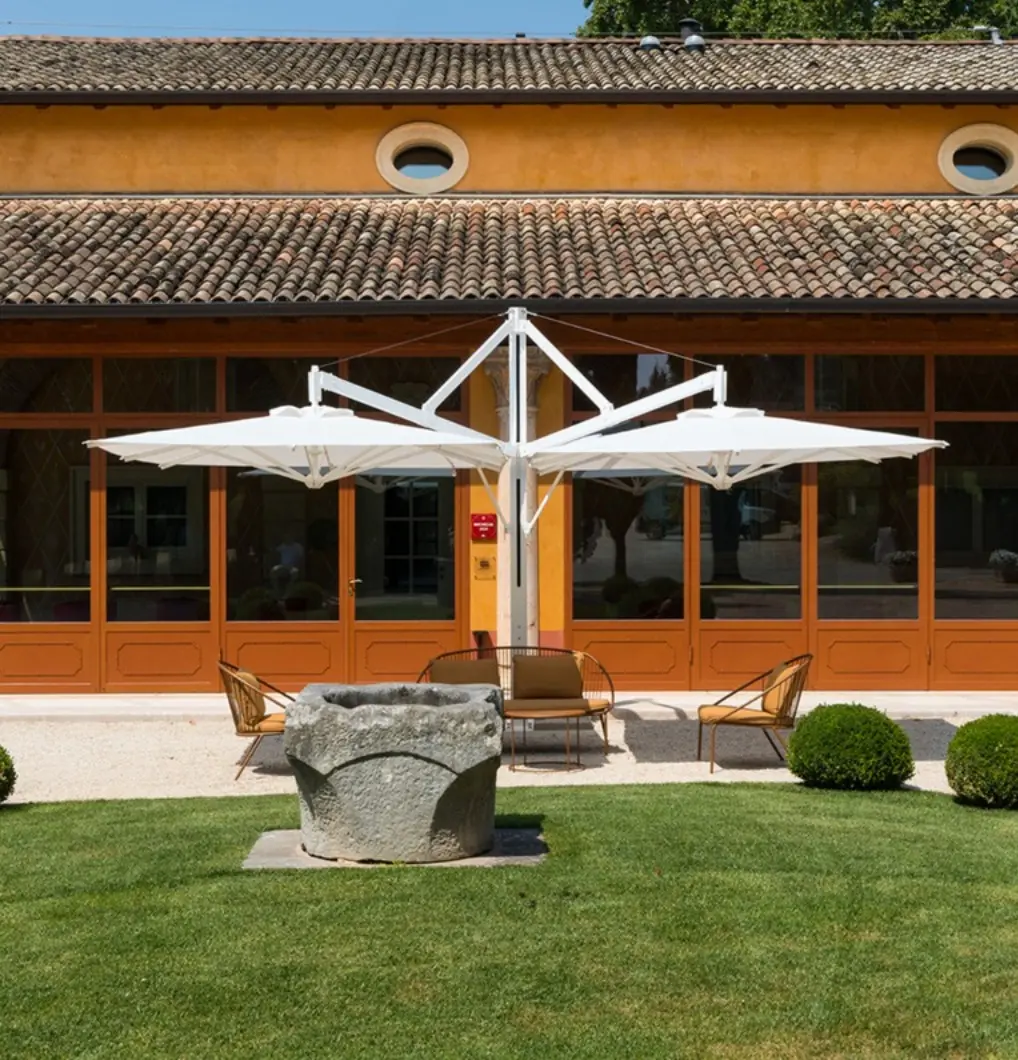 Ombrellone di design bianco con struttura a bracci retrattili.