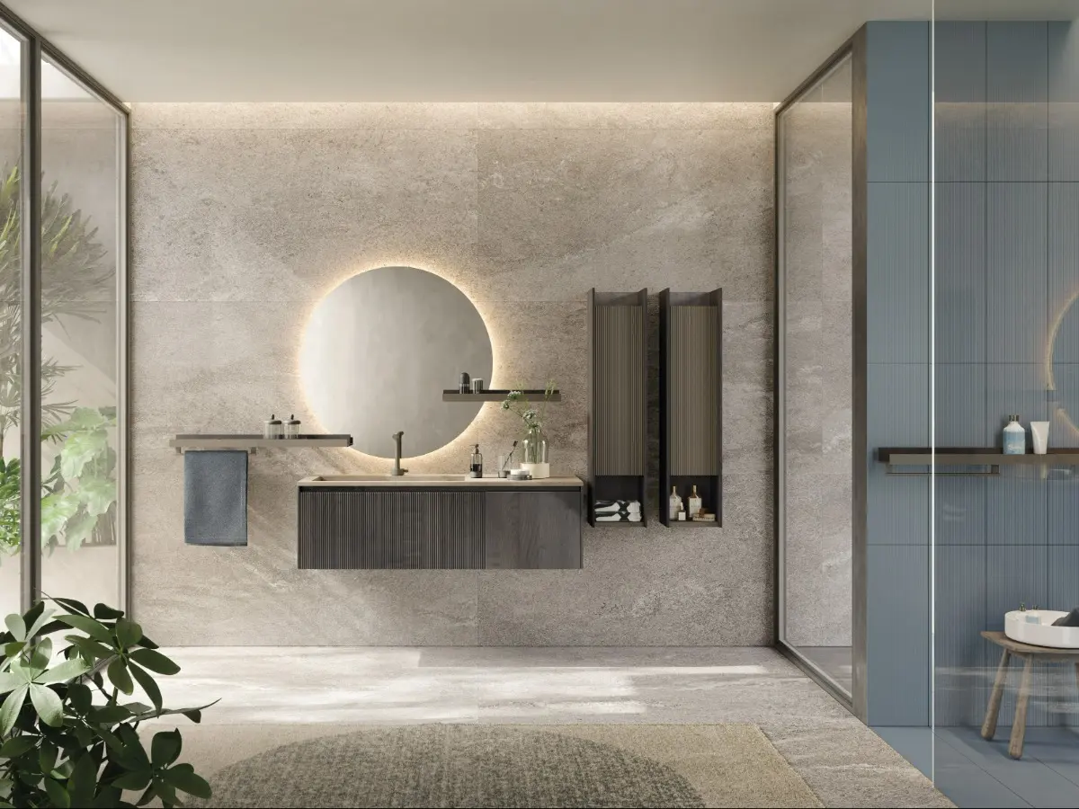 D'Art Bathroom. Wash-basin cabinet with plissé door and flat door in fumo oak, hanging cabinets with plissé door lava matt lacquered and structure in fumo oak, Fokos Roccia porcelain top, bicolor shelves in lava matt lacquer and fumo oak. Towel rail, round mirror with led lighting. 