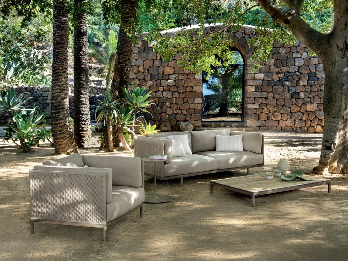 Baia Rope lounge set immersed in greenery, featuring a lounge armchair, sofa and coffee table.