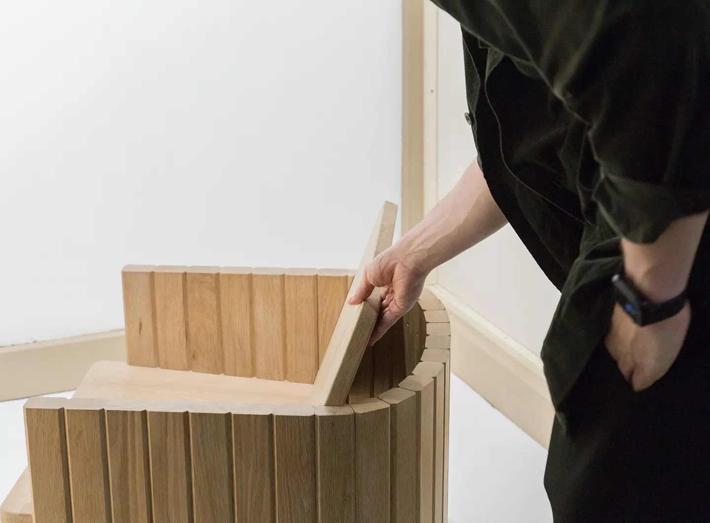 visitor looking at a natural wood chair