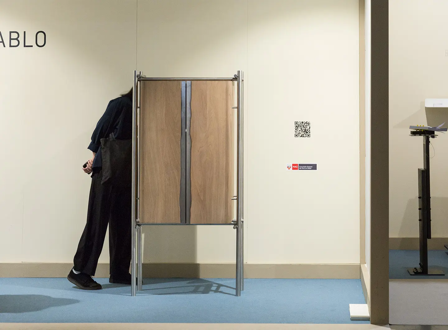Un visitatore guarda un armadio in legno e metallo
