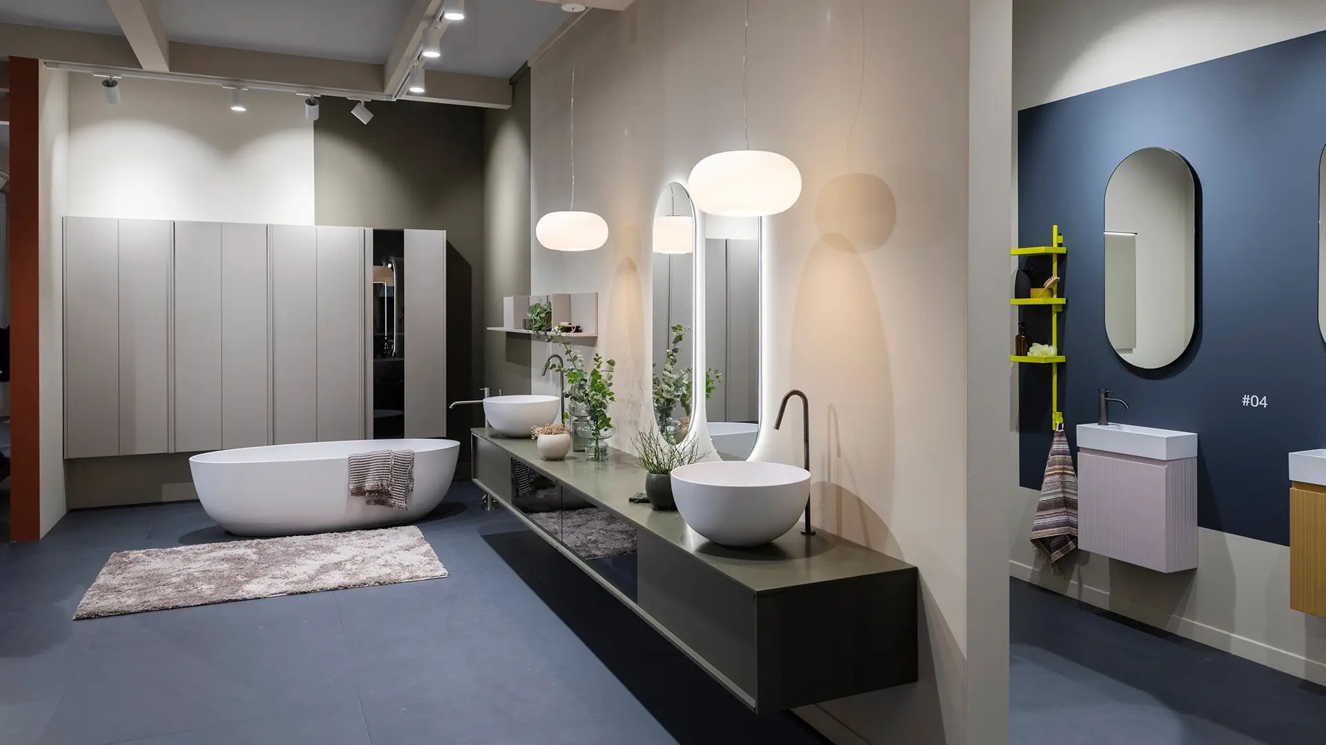bagno con vasca ovale freestanding, mobili da bagno sospesi, lavabi da appoggio e due specchi ovali a parete